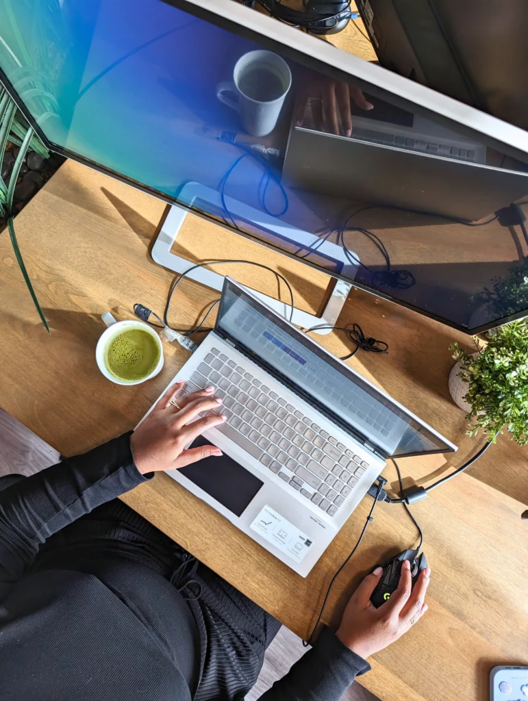 Un espace de travail épuré avec un ordinateur portable ouvert à côté d'une tasse de matcha sur un bureau en bois